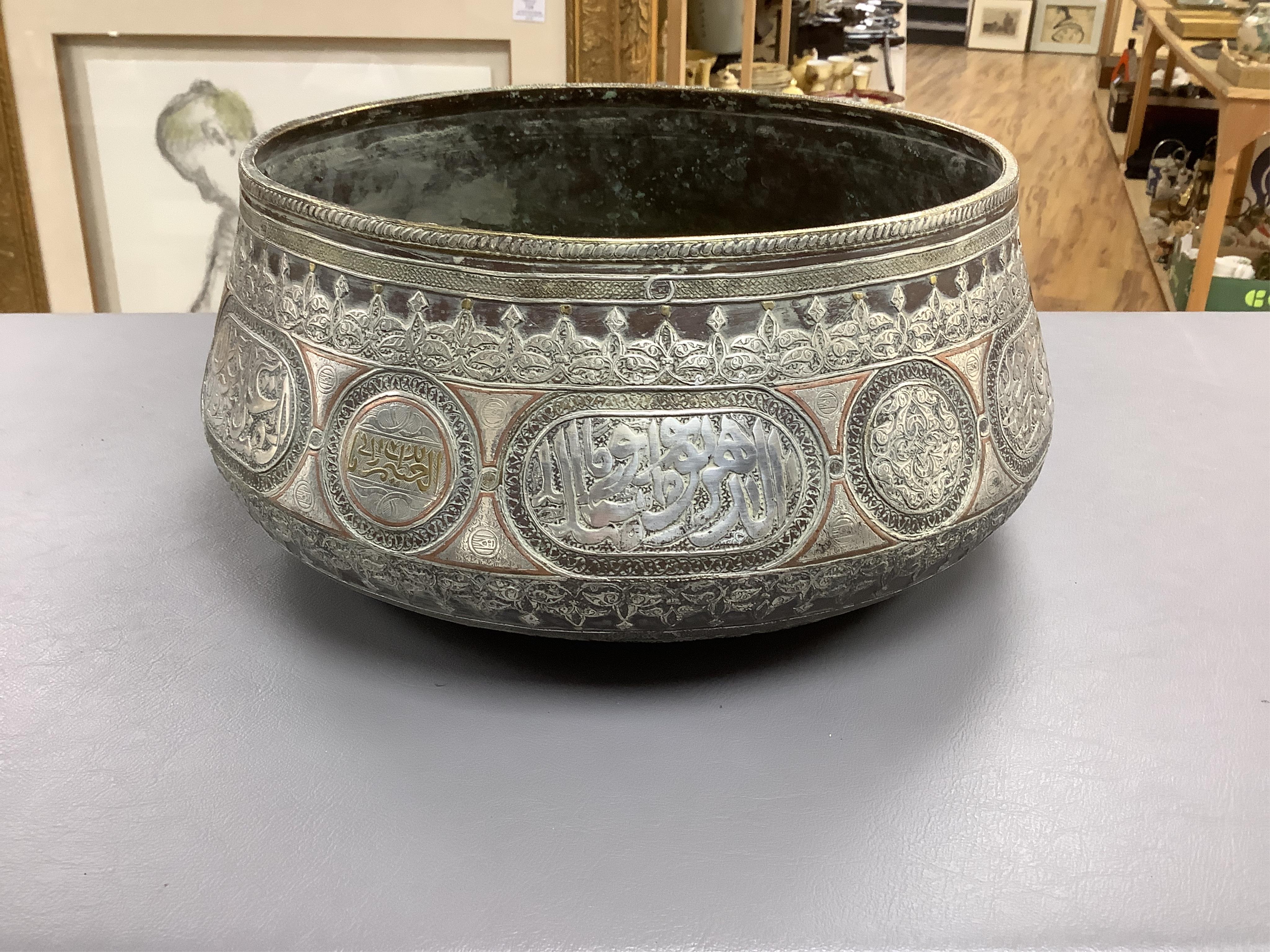 A late 19th century Mamluk style brass basin inlaid with silver and copper decoration, 29cm diameter
